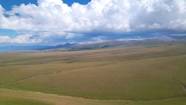 Grands nuages blancs au-dessus des collines et des montagnes vertes