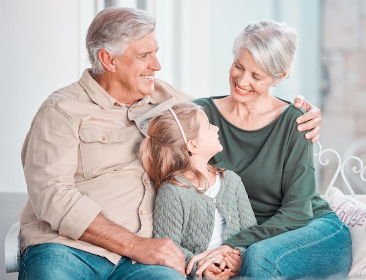 Photo grands-parents enfant et heureux sur le canapé câlin ou mémoire avec soin lien ou amour dans le salon de la maison vieil homme femme âgée et fille avec étreinte sur le canapé du salon se détendre et parler dans la maison familiale