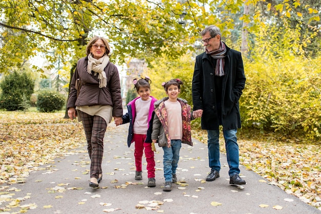 Photo grands-parents avec leurs petits-enfants en automne parc