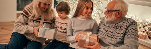 Photo les grands-parents offrant des cadeaux aux enfants