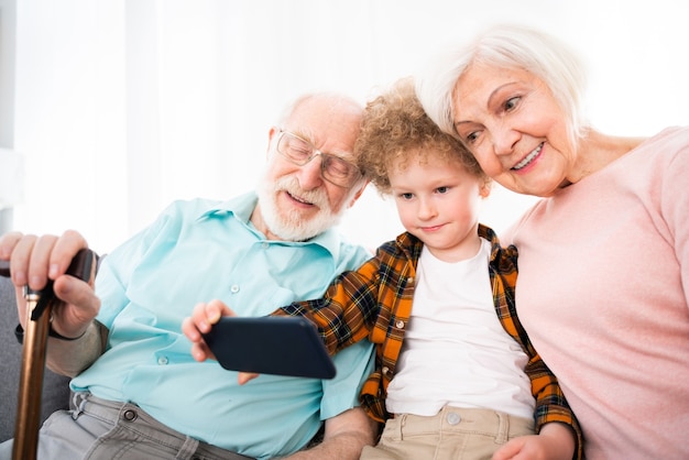 Grands-parents et petit-fils jouant à la maison - Famille à la maison, grand-mère et grand-père prenant soin de son neveu