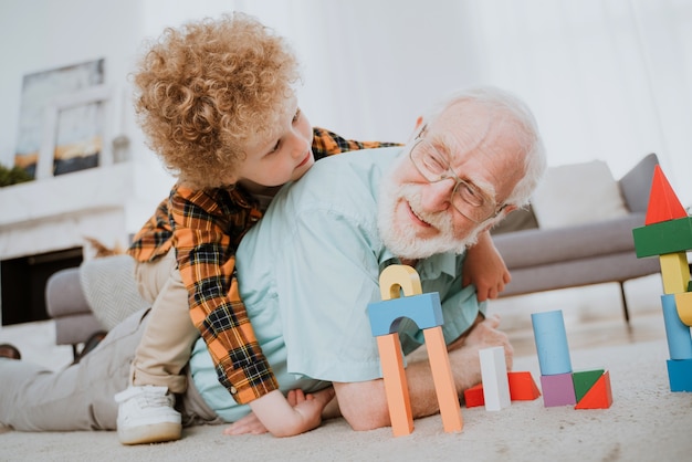 Grands-parents et petit-fils jouant à la maison - Famille à la maison, grand-père prenant soin de son neveu