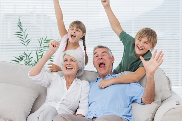 Grands-parents et petits-enfants en train de lever les bras