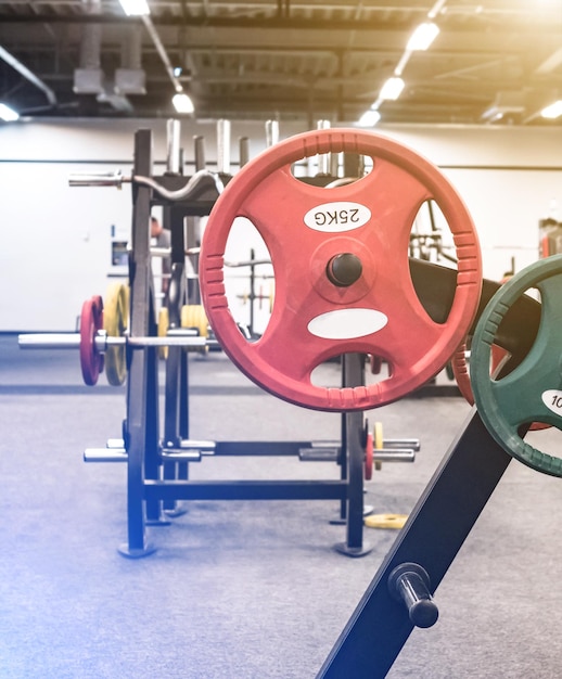 Photo de grands poids rouges ronds prêts pour l'exercice en salle de sport équipés pour la musculation et l'haltérophilie