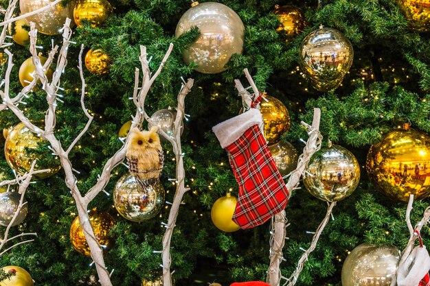 Grands stands de sapin de Noël décorés de boules, de lumières et de jouets dans le centre commercial