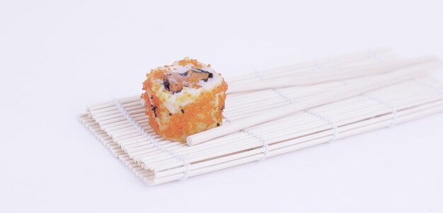 Grands sushis et baguettes isolés sur une lumière