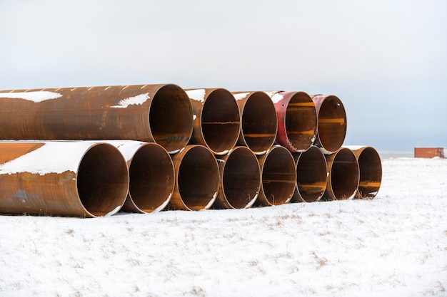 Grands tubes dans la toundra hivernale. Travaux de construction marine en mer. Construction d'un barrage.