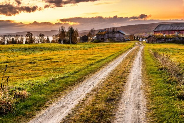 Grange en bois avec ferme au coucher du soleil en Norvège