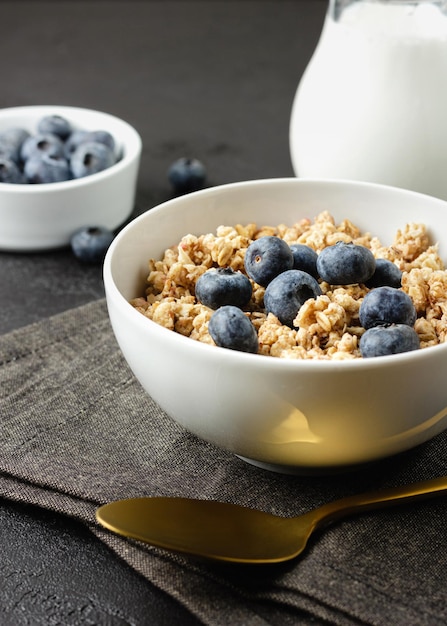 Granola aux bleuets dans un bol sur une serviette sombre