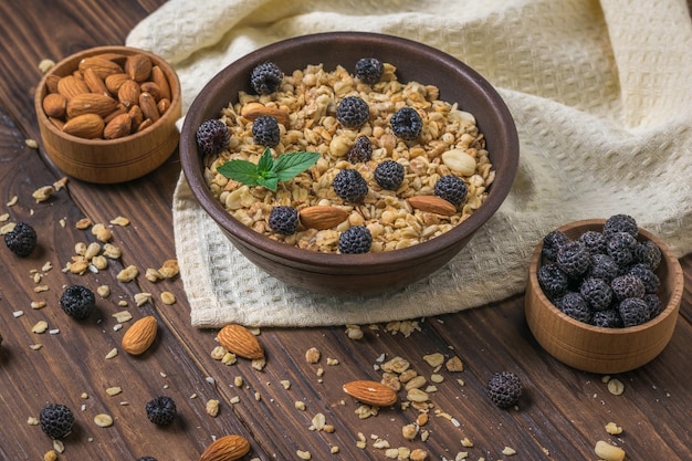 Granola aux framboises noires et amandes sur une table en bois