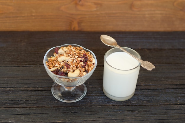 Granola aux fruits rouges et au yaourt sur une table en bois noire. Petit déjeuner américain traditionnel