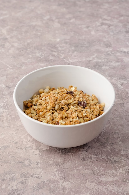 Granola aux noix dans un bol blanc sur fond gris