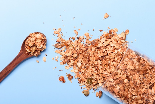 Granola dans un bocal en verre sur fond bleu