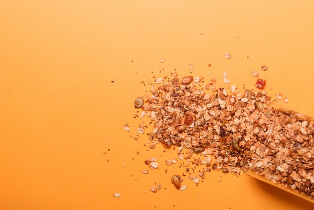 Granola dans un bocal en verre sur fond jaune