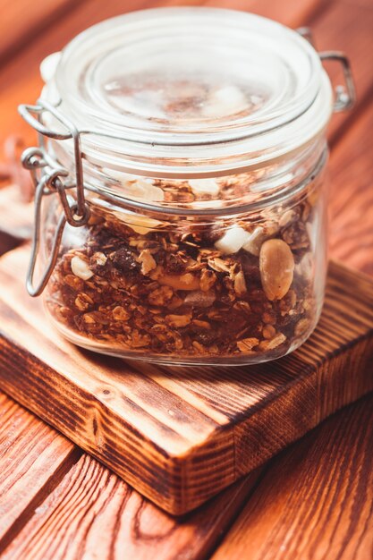 Granola dans un pot sur la table en bois se bouchent