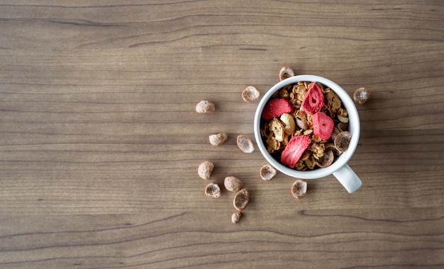 Granola maison au lait pour le petit déjeuner sur la table en bois. vue de dessus