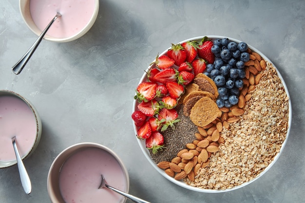 Granola, moitiés de fraises, amandes, graines de chia, myrtilles