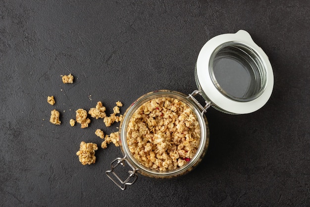 Granola en pot sur fond noir. Nourriture saine. Vue de dessus.