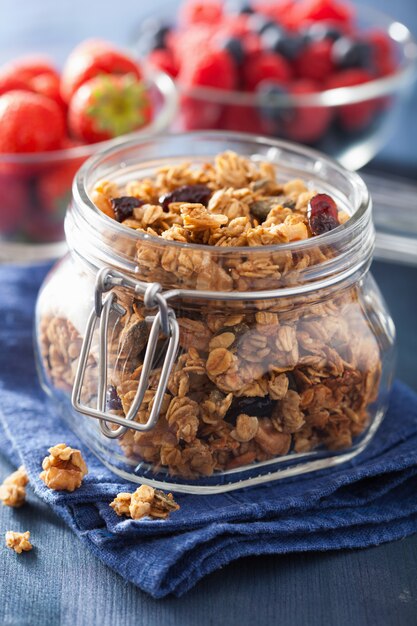 Granola sain fait maison dans un bocal en verre et des baies