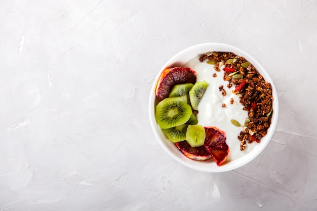 Granola, yaourt au kiwi et oranges rouges.