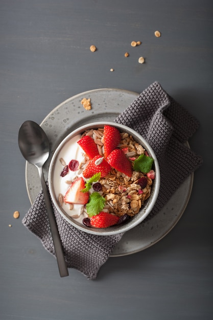 Granola et yaourt aux graines et fraises pour le petit déjeuner