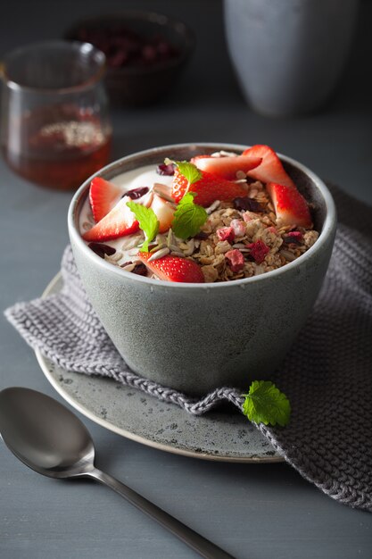 Granola et yaourt aux graines et fraises pour le petit déjeuner