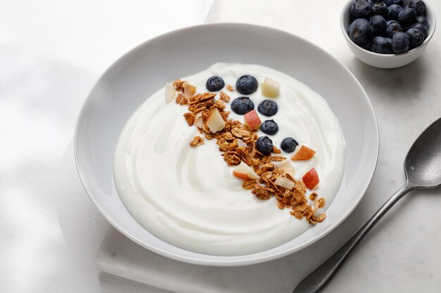 Granola avec yaourt aux noix et baies dans un bol Nature Petit-déjeuner avec yaourt muesli et myrtilles