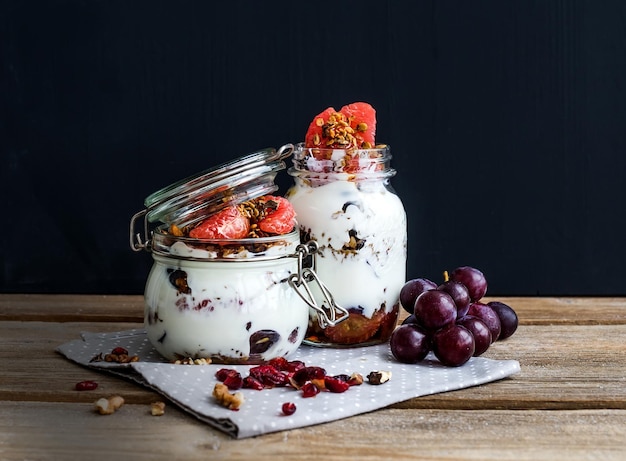 Granola de yaourt et d'avoine aux raisins grenade pamplemousse dans un grand bocal en verre