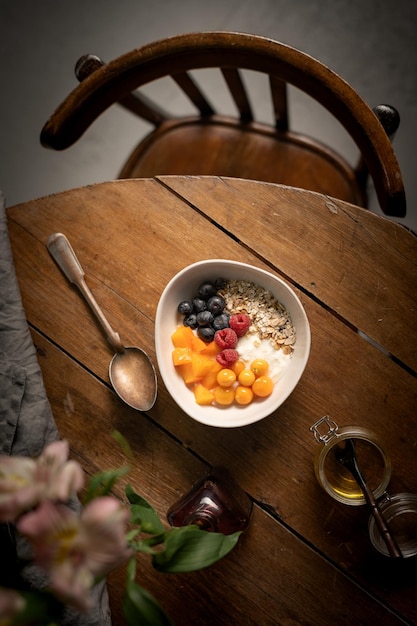 granola avec yaourt et baies sur une table en bois avec chaise