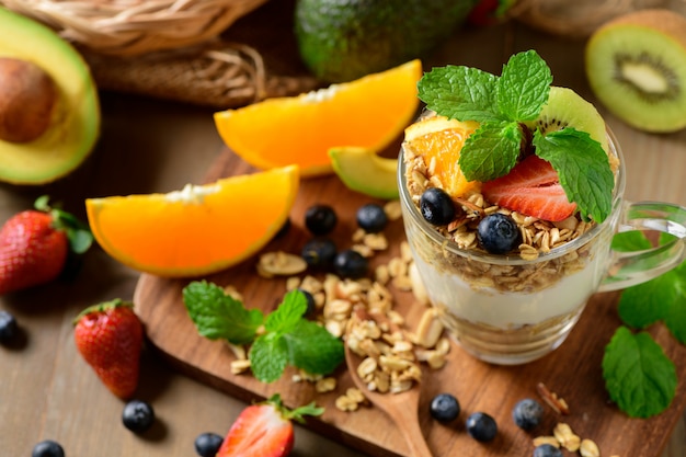 Granola et yaourt et fruits sur la garniture en verre