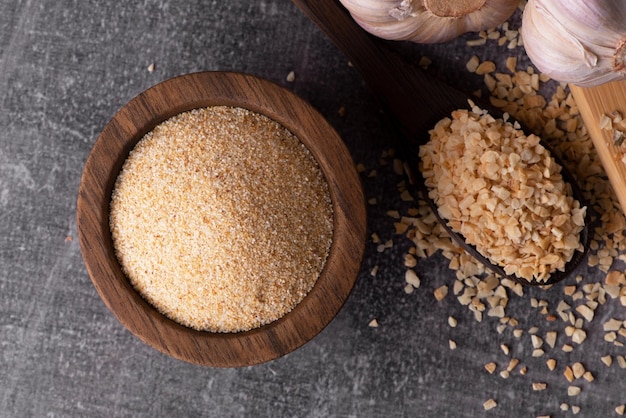 Granules d'ail secs Épices à l'ail Poudre d'ail sec dans un bol et une cuillère en bois