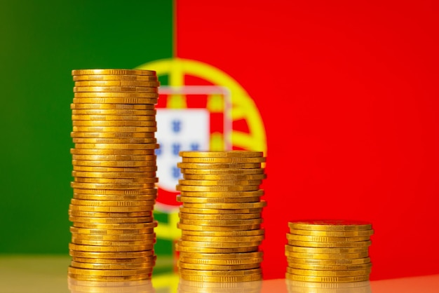 Graphique descendant composé de pièces d'or contre le drapeau du Portugal