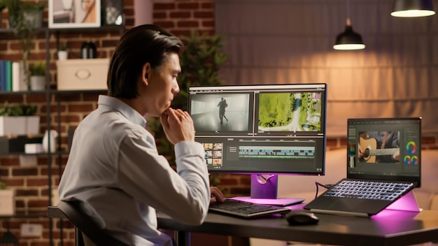 Graphiste développant du contenu cinématographique sur un logiciel de montage, utilisant le multimédia créatif pour la production cinématographique. Conception d'un motage vidéo avec dégradé de couleurs et effets visuels sur ordinateur.