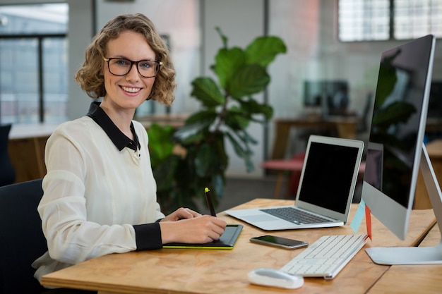 Graphiste féminin assis au bureau