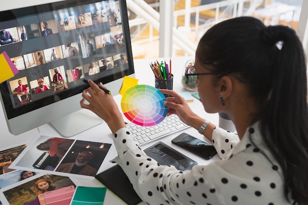 Une graphiste travaillant sur un ordinateur à son bureau