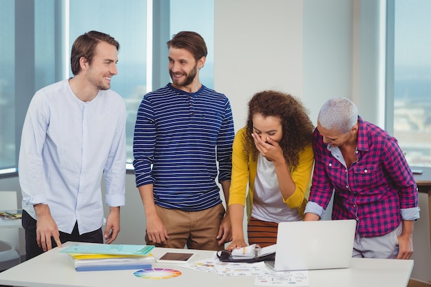 Graphistes souriants interagissant les uns avec les autres