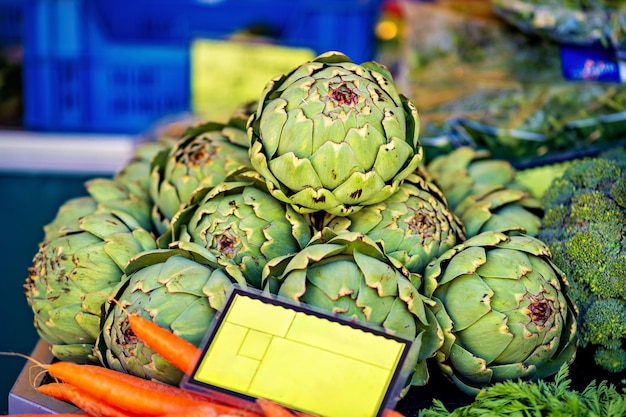 Une grappe d'artichauts et de carottes à vendre au marché