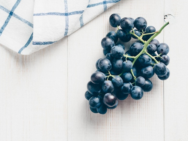 Grappe de raisin noir sur table en bois blanc