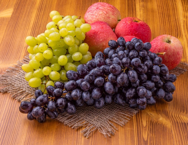 Une grappe de raisin et une poire sur une table en bois