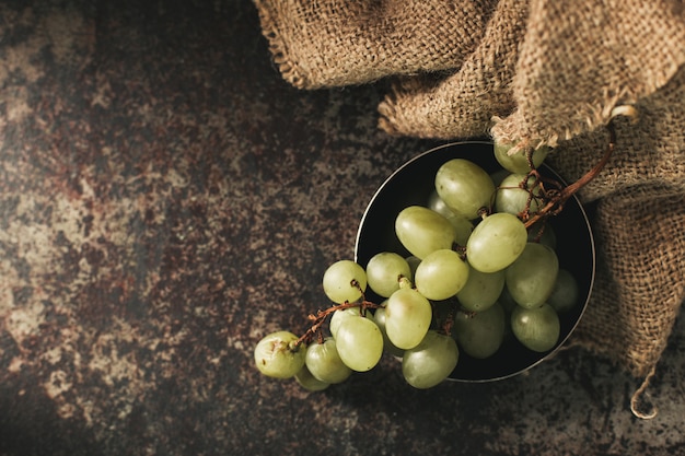 Grappe de raisin vert sur fond sombre.