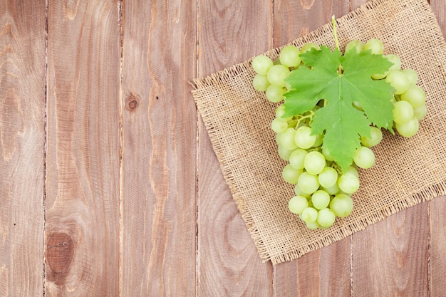 Grappe de raisins blancs avec des feuilles sur bois