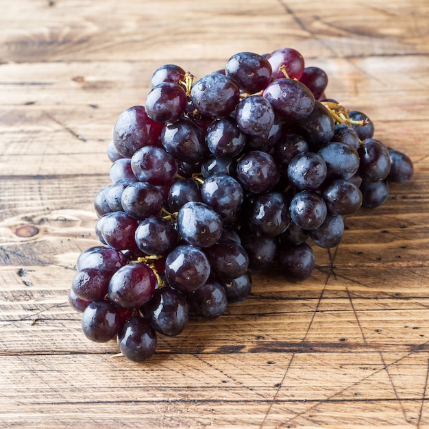 Grappe de raisins noirs frais sur une table en bois