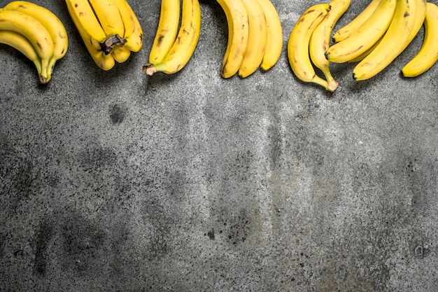 Grappes de bananes fraîches sur table rustique.