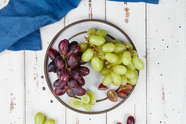 Grappes de raisins verts et rouges mûrs frais sur une table en bois