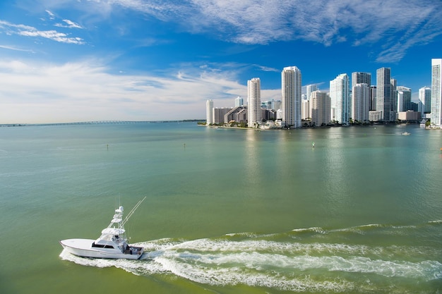 Gratte-ciel de Miami, yacht de luxe blanc naviguant à côté du centre-ville de Miami, vue aérienne