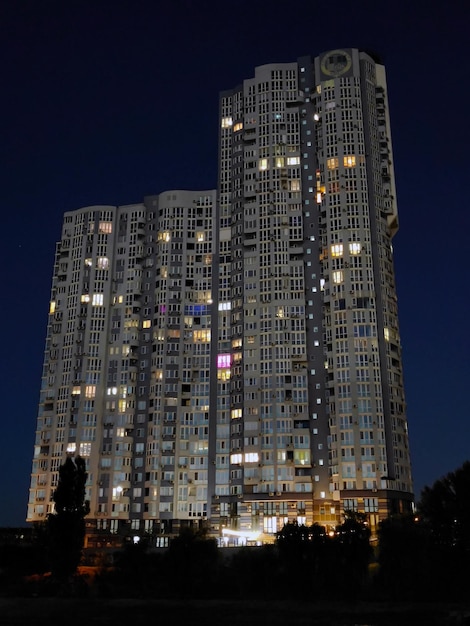 Un gratte-ciel avec de nombreuses fenêtres illuminées sur fond de ciel nocturne