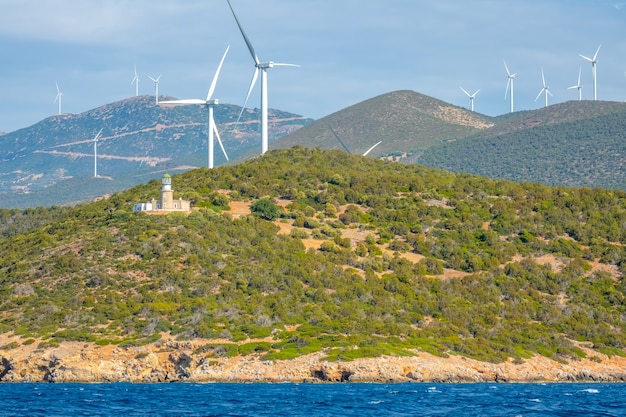 Grèce. Côte vallonnée du golfe de Corinthe en journée ensoleillée. Nombreux parcs éoliens et ancien phare