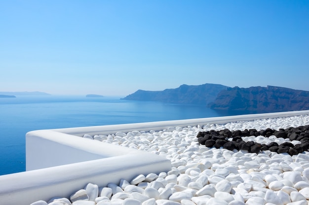 Grèce. Journée ensoleillée à Santorin. L'île de Théra. Pierres noires et blanches sur la terrasse avec vue mer