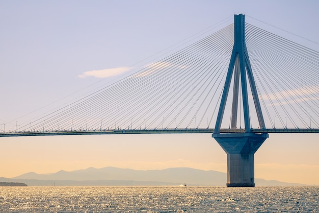 Grèce. Pont Rion Antirion. Haut pylône du pont à haubans sur le golfe de Corinthe et bateau à moteur en journée ensoleillée