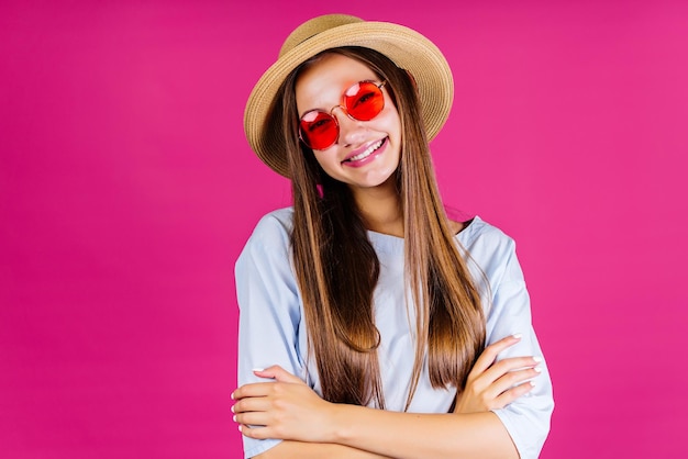 Le greffier d'été dans un chapeau de paille hausse les épaules souriant fond rose